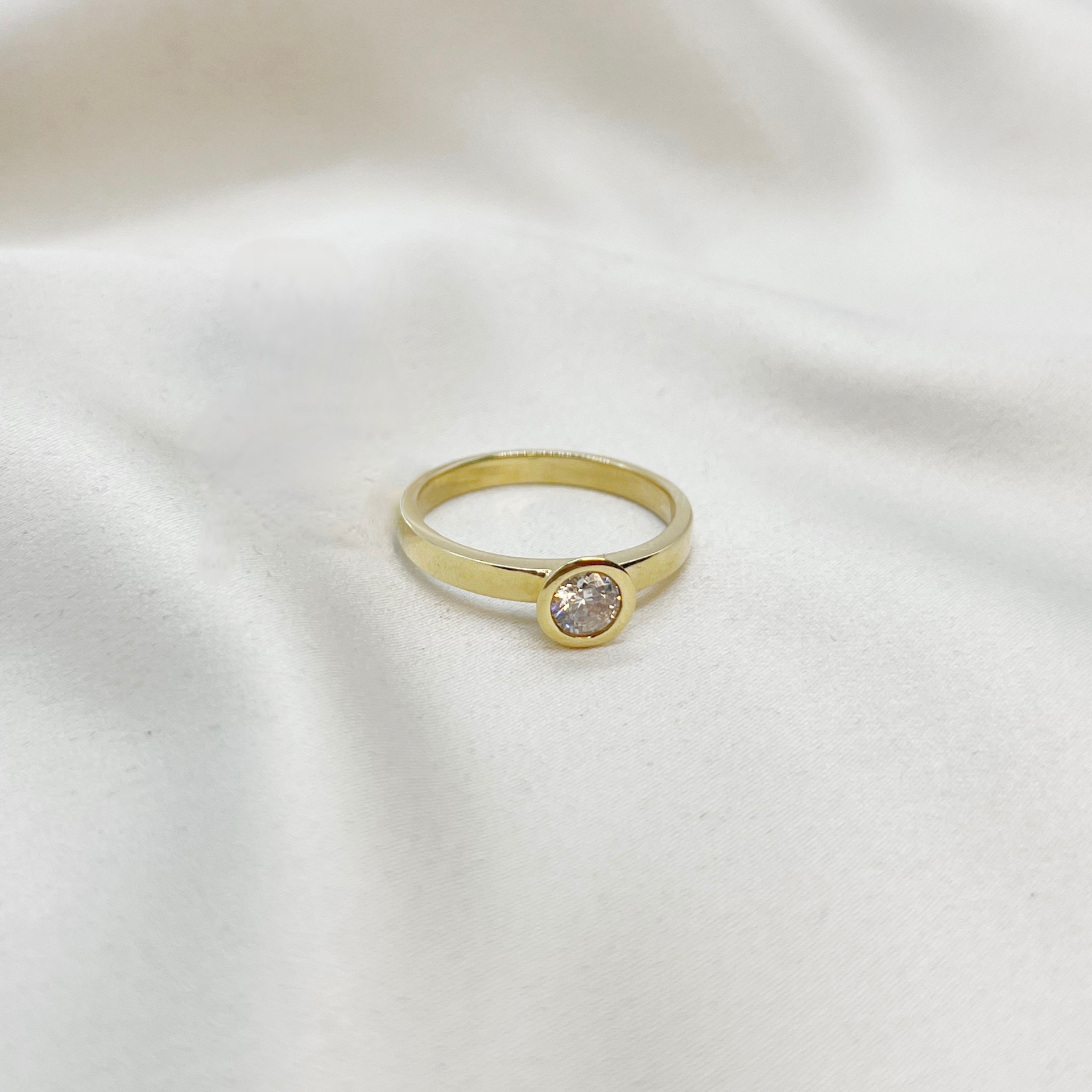 Anillo solitario en bisel con circon en oro amarillo 18kt